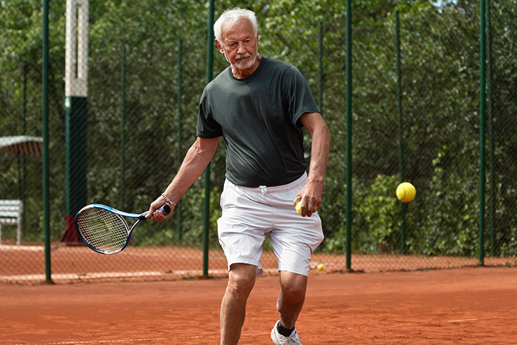 Older man playing tennis