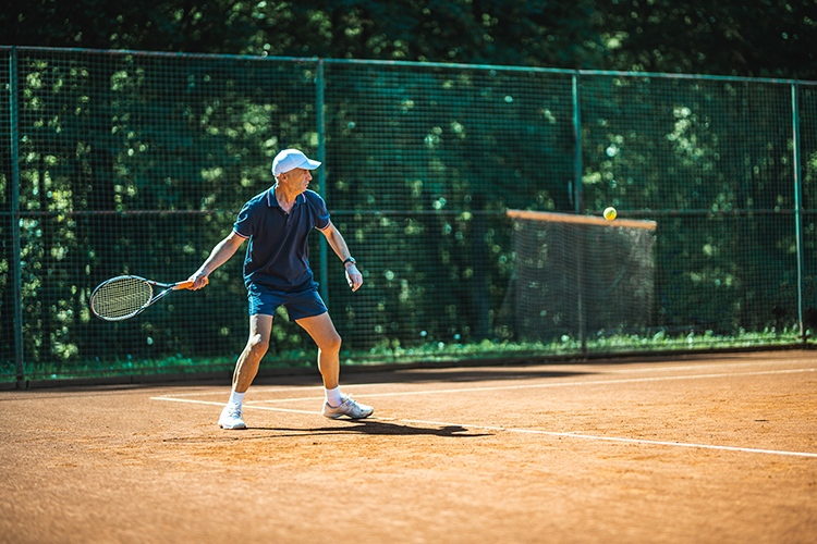 Middle-aged man about to utilize a groundstroke in tennis